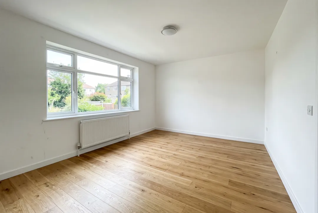 Before: original photo for “Furnish this empty living room in Scandinavian style: a light grey sofa, an oak coffee table, a wool rug, a floor lamp and a few plants. Keep the walls, window, floor and camera angle unchanged.”