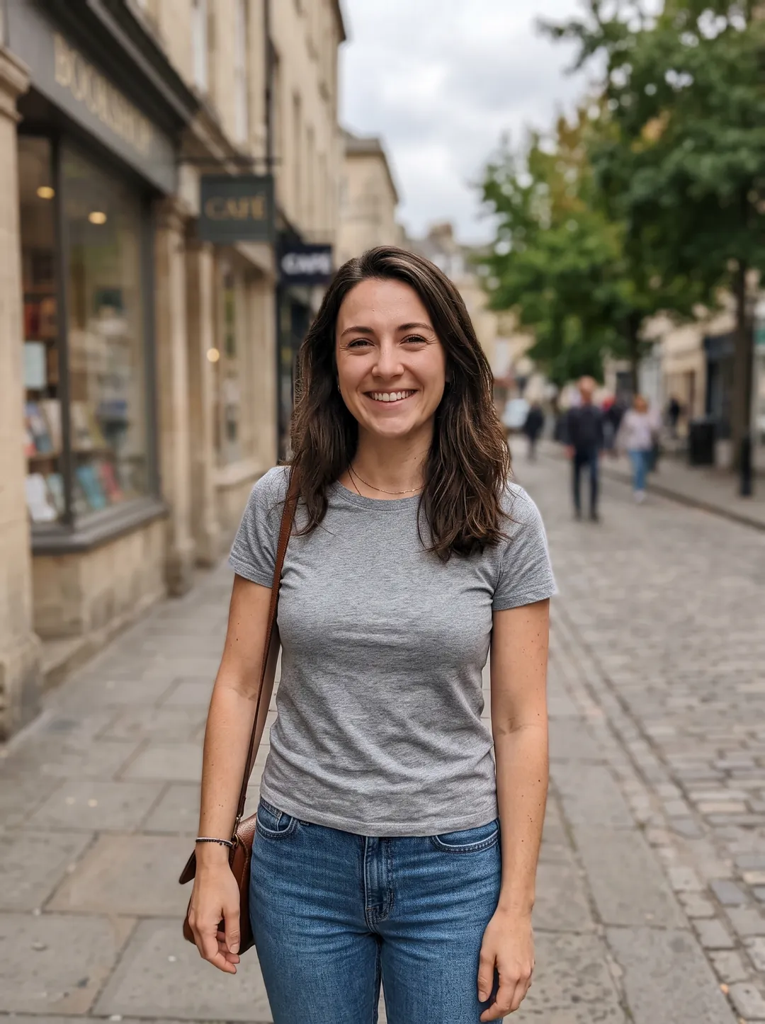 Woman in a grey t-shirt and jeans on a city sidewalk