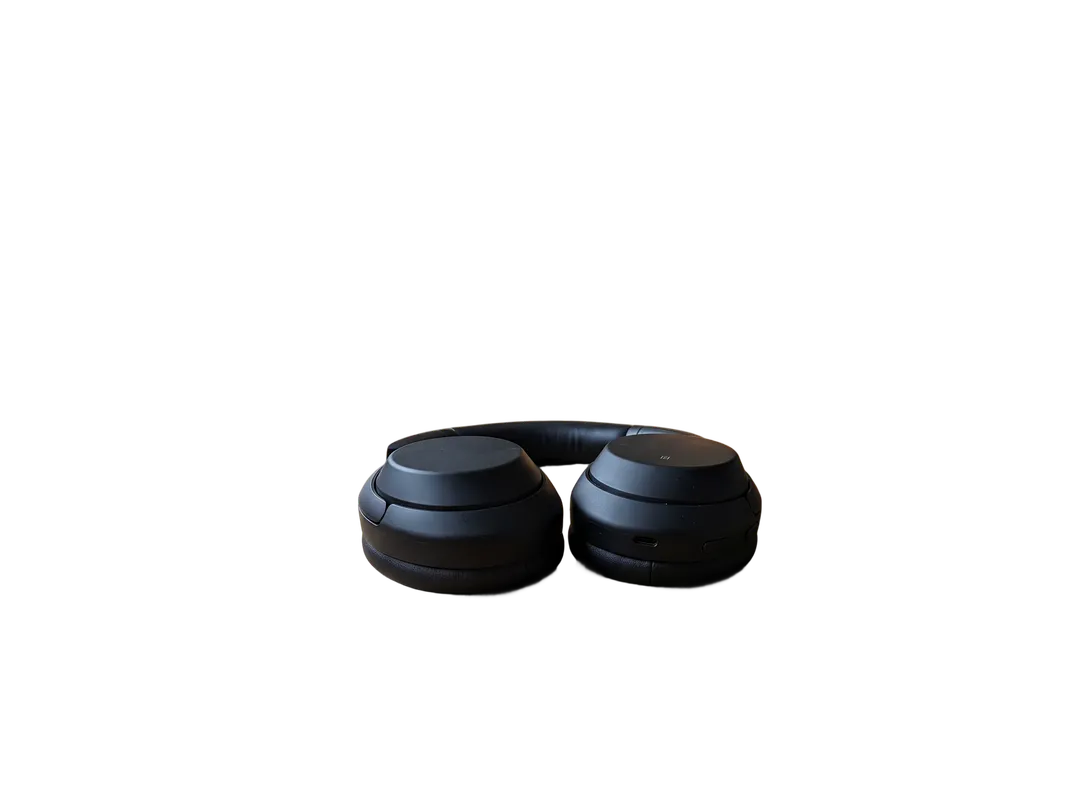 Black over-ear headphones on a wooden desk, background removed (transparent PNG)