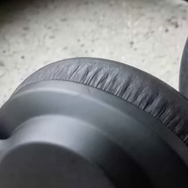Matte black over-ear headphones on concrete, upscaled 4× with AI, 100% crop
