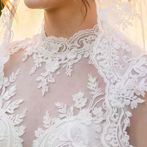 Bride in a lace veil holding white roses, upscaled 4× with AI, 100% crop