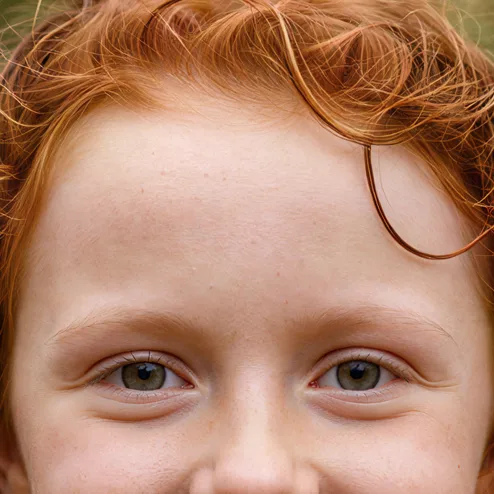 Freckled red-haired girl in a yellow raincoat, upscaled 4× with face enhancement on
