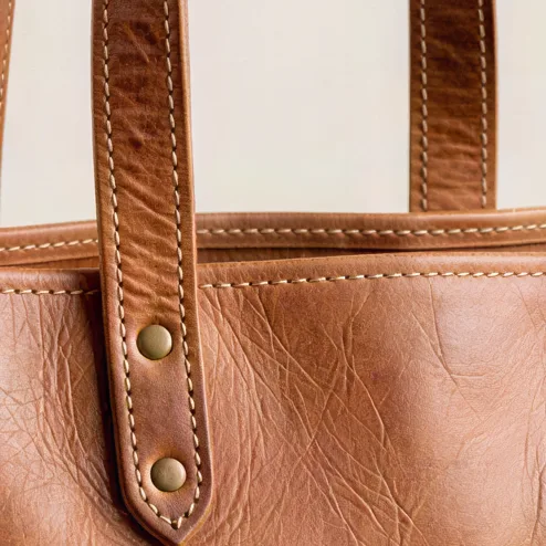 Tan leather tote bag with visible stitching, upscaled 4× with AI, 100% crop