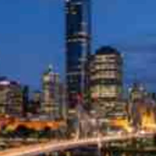 City skyline across a river at blue hour, low-resolution original, 100% crop