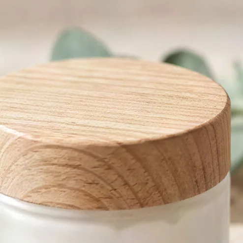 Frosted cream jar and dropper bottle on travertine, upscaled 4× with AI, 100% crop
