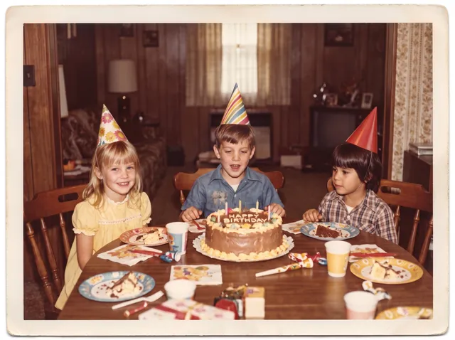 Restored photo of a 1970s children’s birthday table with a cake
