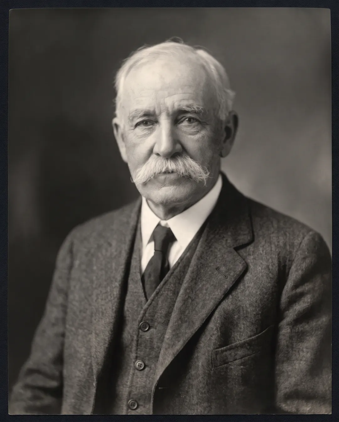 Restored photo of a 1930s studio portrait of an elderly man with a white mustache