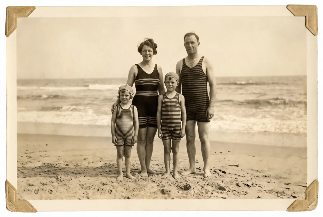Restored photo of a 1930s family in striped bathing suits at the seaside
