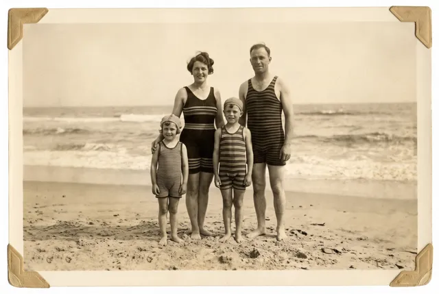 Restored photo of a 1930s family in striped bathing suits at the seaside