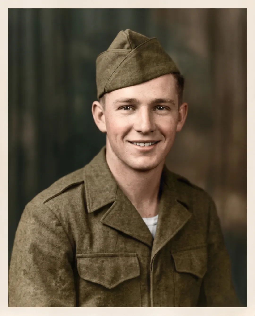 Photo of a 1940s portrait of a young soldier in a garrison cap, colorized