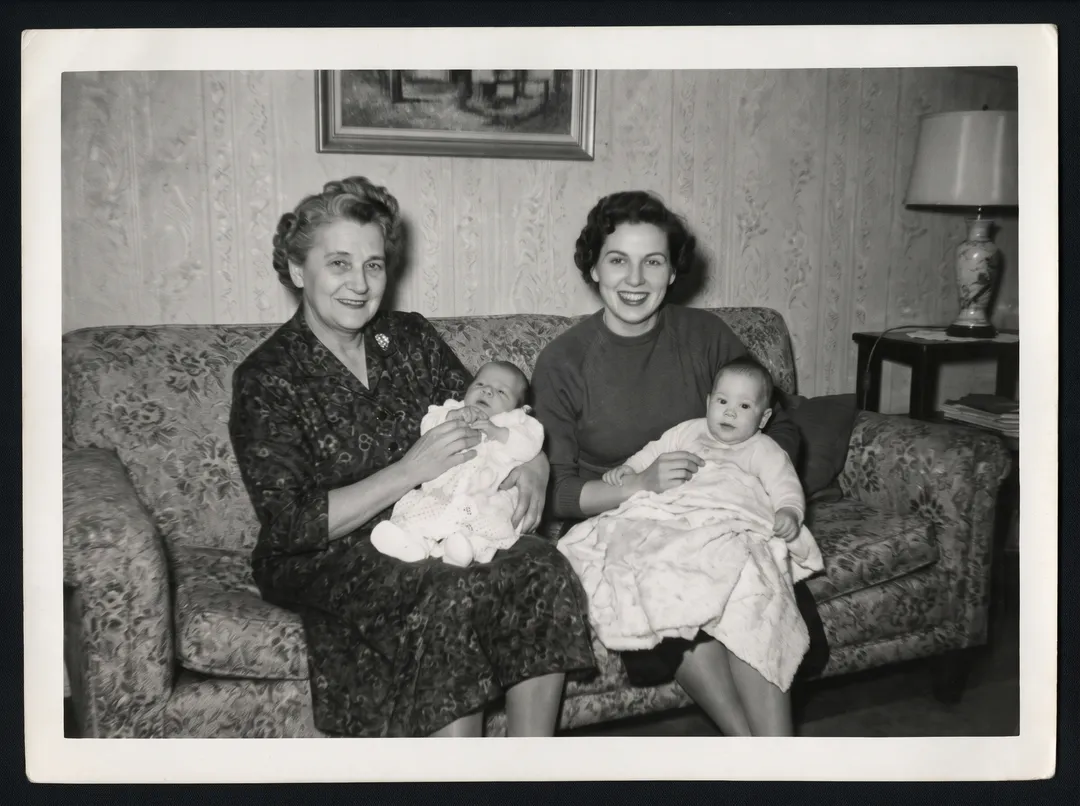 Restored photo of three generations of a 1950s family on a patterned sofa