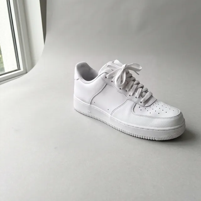 White leather sneaker on a gray backdrop, after removing the cable and sticker