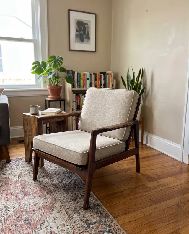 Mid-century wooden armchair for a resale listing, after removing the laundry basket and vacuum cleaner