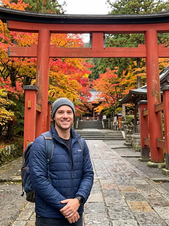 Photo of a man in a navy jacket in front of a red wooden temple gate in autumn, after removing visitors walking through the gate